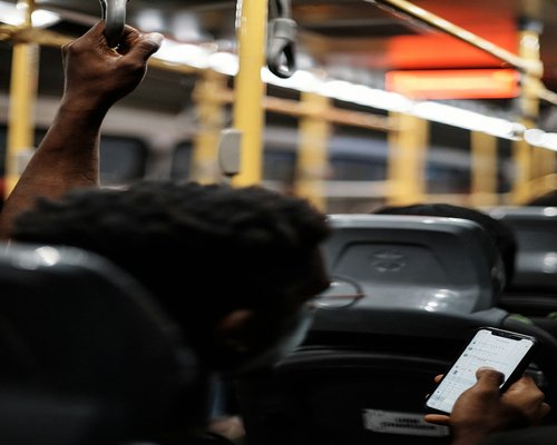 Person holding a smartphone in public transport
